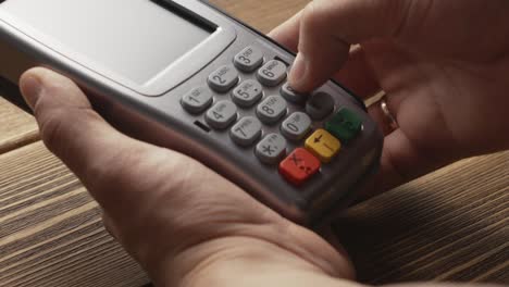 Person-pushing-the-button-and-swipe-credit-card-payment-on-pos-terminal