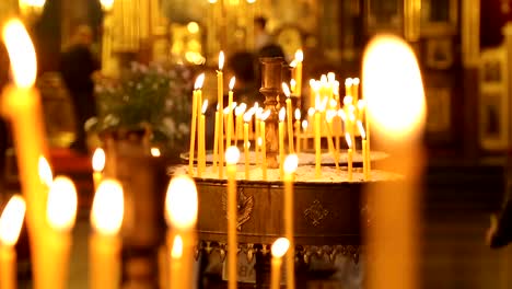 Burning-candles-inside-of-orthodox-church,-paying-respects,-religious-tradition