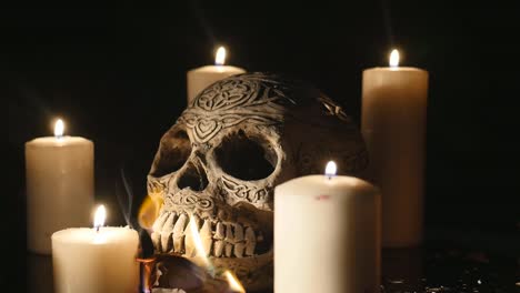 Burning-dollars-with-four-lighted-candles-and-a-skull-close-up-over-black-background