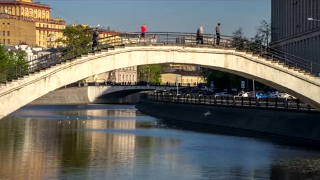 people-crossing-the-city's-canal-at-the-hump-backed-bridge,-time-lapse