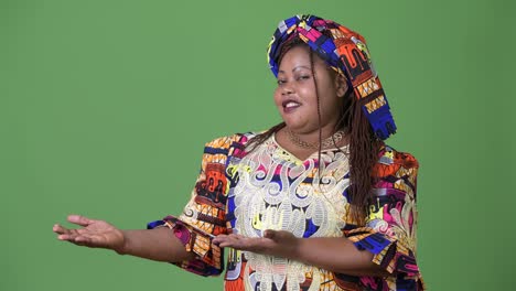 Overweight-beautiful-African-woman-wearing-traditional-clothing-against-green-background