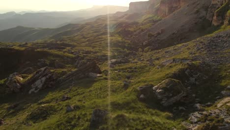 Ein-Blick-von-oben-auf-ein-Tal,-gesäumt-von-großen-Steinen-am-Fuße-einer-hohen-Klippe.-Ein-Sonnenuntergang-Panorama-des-Kaukasus-mit-einer-Umdrehung.-Überprüfung-der-epischen-Ort-in-4-k-100-Mbit/s