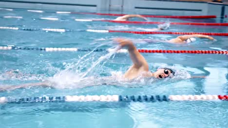 High-angle-male-sportsman-floating-in-crawl-style-by-tracks-at-swimming-pool-championship