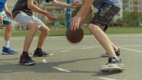 Junger-Mann-am-Basketballplatz-mit-Ball-dribbeln