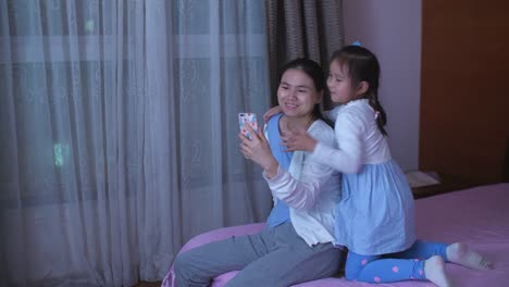 Mother-and-daughter-using-phone-in-home,-4k