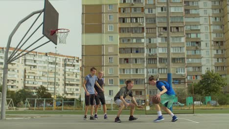 Adolescentes-amigos-jugando-streetball-en-cancha-al-aire-libre