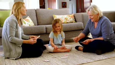 Múltiples-generaciones-familiares-jugando-cartas-en-sala-4-k