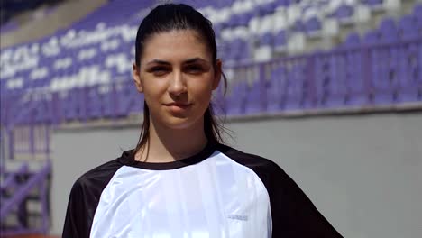 Portrait-of-young-woman-footballer-with-football-soccer-ball-on-stadium,-4k