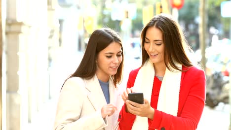 Friends-talking-about-phone-content-in-winter