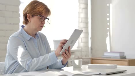 Alte-Frau-mit-Tablet-am-Arbeitsplatz