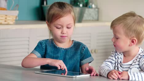 Niños-caucásicos-usando-tableta-juntos-en-casa