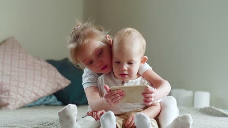 Girl-Teaching-Baby-Brother-How-to-Use-Tablet