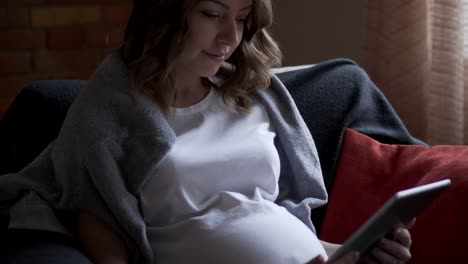 Pregnant-woman-using-digital-tablet-at-home