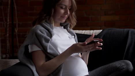 Pregnant-woman-messaging-on-mobile-phone