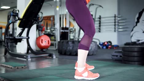 Young-beautiful-girl-doing-squats-in-the-gym.-close-up-of-legs,-4k.-Concept-of-sport-and-healthy-lifestyle.