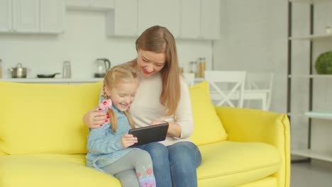 Charming-mom-and-daughter-working-on-tablet-pc