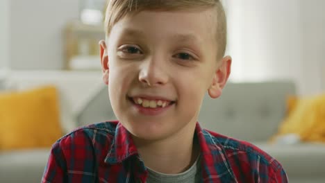 Portrait-of-Adorable-Young-Boy-Smiling-on-Camera.-In-the-Background-Blurred-Sunny-Room.