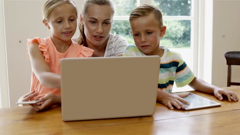 Mother-and-children-using-laptop