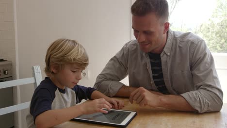 Padre-e-hijo-usando-Tablet-PC-en-la-mesa-de-la-cocina,-filmado-en-R3D