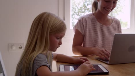 Papá-cocinando-y-mamá-con-niños-en-la-mesa-de-la-cocina,-filmado-en-R3D