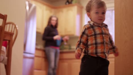 A-little-boy-walking-through-the-kitchen-and-living-room-to-play-with-his-toys