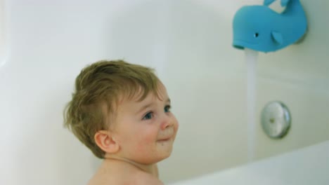 Adorable-little-boy-sits-in-the-bathtub-as-the-water-fills-up