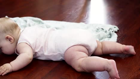 Adorable-little-baby-lie-on-floor-on-stomach.-Apartment.-Cute-movements