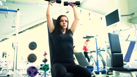 Strong-brunette-woman-doing-exercise-in-fitness-club