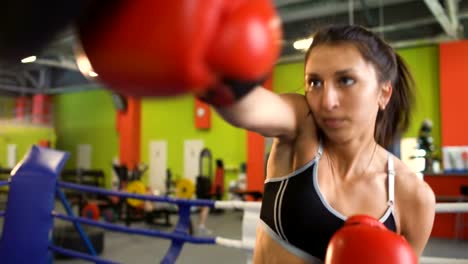 El-entrenamiento-de-la-mujer-joven-boxeador-pre-partido-de-calentamiento-en-el-ring-de-boxeo-con-su-entrenador