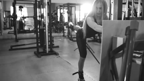 Strong-blonde-woman-doing-exercise-wtiht-lifting-weights-in-fitnest-club