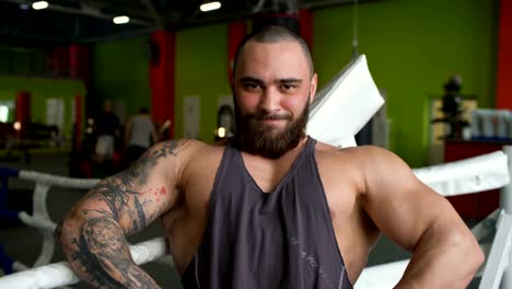 Handsome-sporty-man-smile-and-posing-into-camera-in-fitness-club