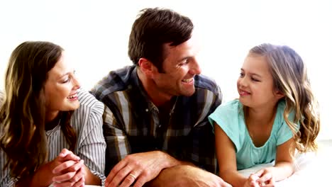 Glückliche-Familie-entspannend-auf-Bett-im-Schlafzimmer