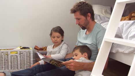 Padre-leyendo-historia-a-los-niños-en-su-habitación