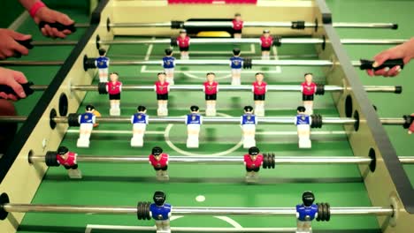 playing-table-football,-closeup-view-of-people-playing-table-soccer,-blue-and-red-plastic-figures