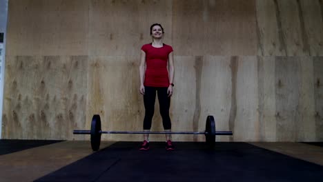 Athletic-Woman-Athlete-Portrait-Standing-In-Front-Of-Weights-Before-Lifting-In-Center-Happy-Smiling