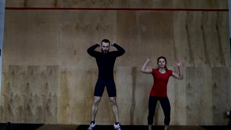 Young-Athletes-Couple-Doing-Burpee-Exercise-During-Workout-Training-At-Gym