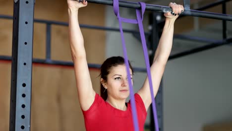 Woman-Hanging-On-Bar-Doing-Pulling-Up-Exercise-During-Workout-Training-At-Gym