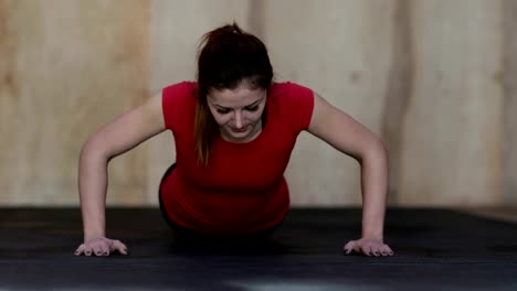 Young-Woman-Doing-Push-Ups-Exercise-During-Workout-Training-At-Gym