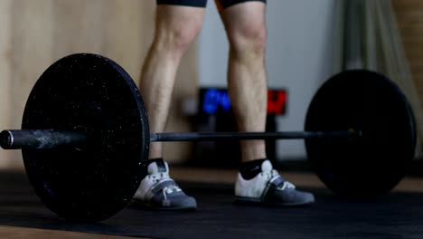 Hombre-se-prepara-para-levantar-la-pesada-barra-haciendo-ejercicio-durante-el-entrenamiento-de-ejercicio-en-el-gimnasio-de-Halterofilia