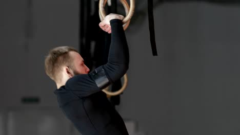 Young-Man-Exercising-On-Gymnastic-Rings-During-Workout-Training-At-Gym