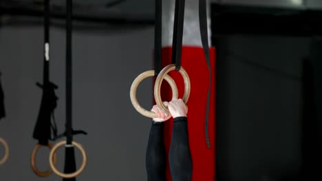 Young-Man-Exercising-On-Gymnastic-Rings-During-Workout-Training-At-Gym