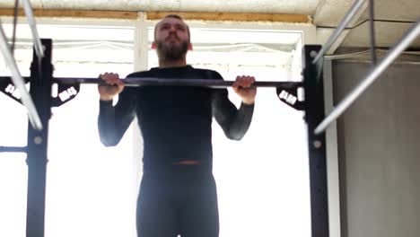 Mann-hängen,-Bar,-Kerl-dabei-hochziehen-Übung-beim-Workout-Training-im-Fitnessstudio