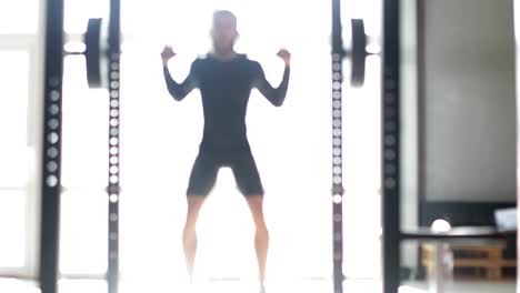 Joven-haciendo-ponderado-de-ejercicio-sentadillas-en-máquina-Smith-durante-el-entrenamiento-de-ejercicio-en-el-gimnasio