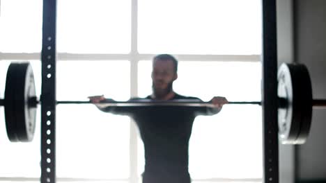 Young-Man-Exercising-Doing-Weighted-Squats-On-Smith-Machine-During-Workout-Training-At-Gym