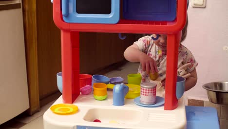 Two-sisters-playing-in-toy-kitchen