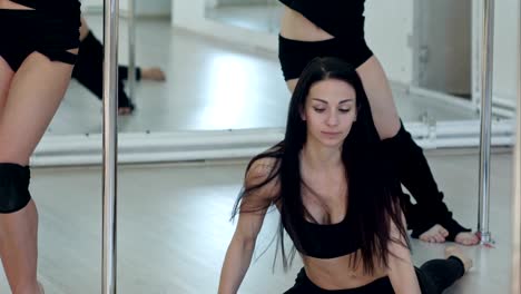 Group-of-young-women-stretching-before-pole-dance-class