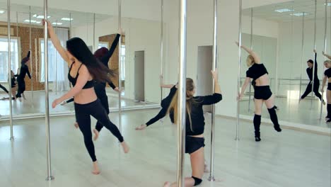 Gruppe-von-hispanischen-Frauen-dehnen-und-Aufwärmen-für-ihre-Pole-Dance-Klasse