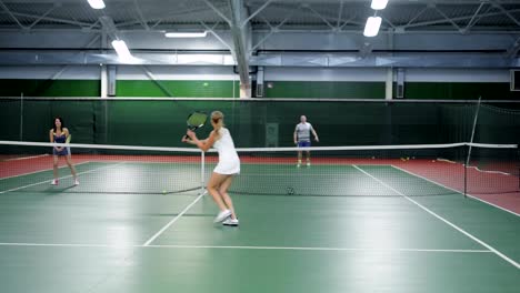 Two-teams-playing-tennis-in-double-game.-Women-and-men-players-practicing