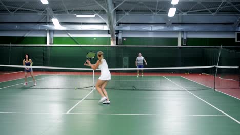 Dos-equipos-jugando-al-tenis-en-doble-juego.-Jugadores-hombres-y-mujeres-practicando