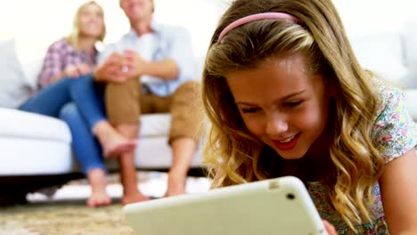 Daughter-using-digital-tablet-in-living-room-while-parents-sitting-on-sofa-4k